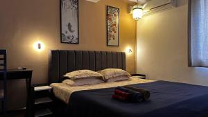 a bedroom with a bed with two pillows on it at The Burrow in South Goa. in Dabolim