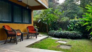 two chairs sitting on the porch of a house at The Burrow in South Goa. in Dabolim