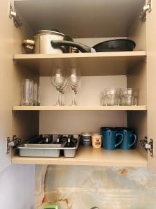 two wine glasses and other items on shelves in a kitchen at Plaza di Drama in Drama