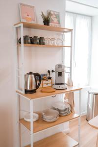 a shelf with plates and a coffee maker on it at Charmant T2 plein centre in Saint-Astier