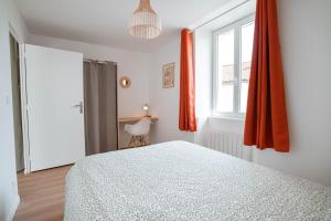 a bedroom with a bed and a window with orange curtains at Charmant T2 plein centre in Saint-Astier
