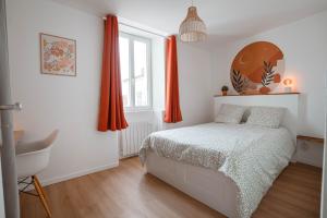 a bedroom with a bed and a window with orange curtains at Charmant T2 plein centre in Saint-Astier