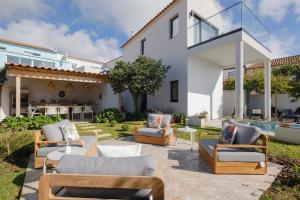 a patio with couches and chairs in front of a house at Solar do Sabão - Your Gathering Place in Relva