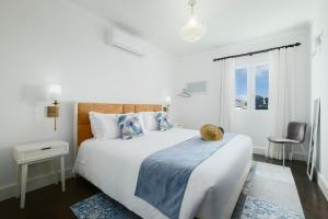 a white bedroom with a large bed and a window at Solar do Sabão - Your Gathering Place in Relva +85 photos