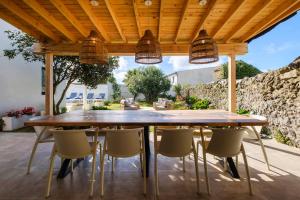 a wooden table and chairs under a wooden ceiling at Solar do Sabão - Your Gathering Place in Relva