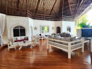 Una sala de estar con un sofá y un televisor en Lilys Haven, en Malindi