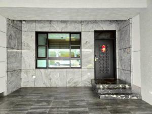 una puerta de entrada de un edificio con una corona en 東港包棟 悠舍民宿, en Donggang