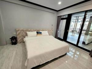 東港鎮にある東港包棟 悠舍民宿の大きなベッドと大きな窓のある寝室