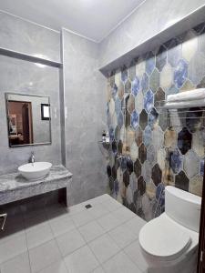 東港鎮にある東港包棟 悠舍民宿のトイレ、洗面台、鏡のあるバスルーム +14枚の写真