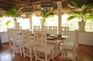 comedor con mesa, sillas y palmeras en Lilys Haven, en Malindi