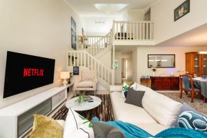 un soggiorno con un divano bianco e una TV di Golfers Delight View of 15th hole and Tennis a Mollymook