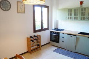 a kitchen with a stove and a sink and a window at Casa Florian in Vito dʼAsio