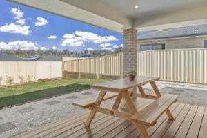 a wooden picnic table sitting on a deck at Casa de Soleil New Modern Home Central Location in Worragee