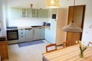 eine Küche mit weißen Schränken und einem Holztisch mit einem Esszimmer in der Unterkunft Casa Florian in Vito dʼAsio + 19 Fotos