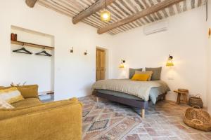 a bedroom with a bed and a couch in a room at Terres Élaïs in Robion en Luberon +60 photos