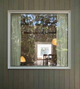 嬬恋村にあるWHITE HUT l ホワイトハットのテーブルとテーブルサーチャーのある部屋の窓