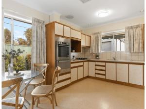 a kitchen with a table and chairs and a dining room at Spacious and Modern Guest House in Gilles Plains +31 photos
