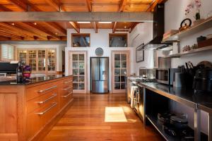 a large kitchen with wooden cabinets and a refrigerator at Vince's Landing - Stunning Big Private Waterfront Cottage in Erowal Bay