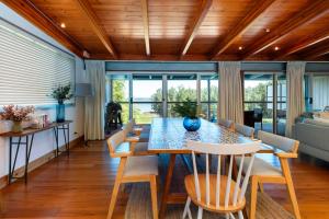 ein Esszimmer mit Tisch und Stühlen in der Unterkunft Stunning Big Private Waterfront Cottage in Erowal Bay