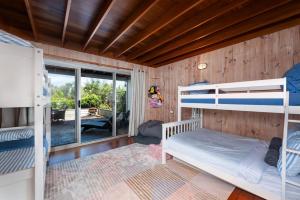 1 Schlafzimmer mit 2 Etagenbetten und einem Balkon in der Unterkunft Stunning Big Private Waterfront Cottage in Erowal Bay