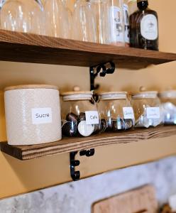 ein Regal mit darauf stehenden Gläsern mit Etiketten in der Unterkunft Chalet romantique & SPA in Montignac-Charente