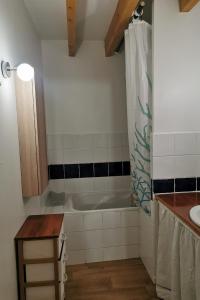 ein Badezimmer mit Badewanne und Waschbecken in der Unterkunft Les Gites de Louisette Le 974 in Ébreuil