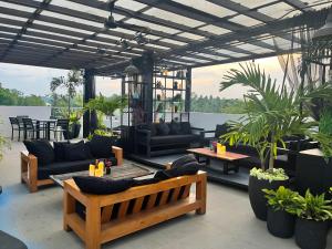 eine Terrasse mit Sofas, Tischen und Pflanzen in der Unterkunft Hotel Bijoux in Plaridel