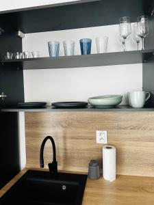 een aanrecht met kommen en glazen op een plank bij Cozy home in Galanta in Galanta