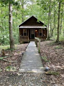 a wooden path leading to a cabin in the woods at Rustic Cabin on 28-Acre Property in the Foothills of the Blue Ridge Mountains in Elkin