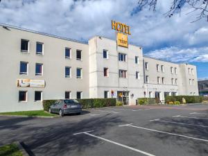 a large white building with a hotel sign on it at Premiere Classe Caen Nord - Mémorial in Caen