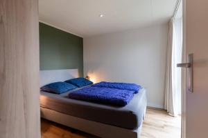 En eller flere senge i et værelse på Hello Zeeland - Holidayhome Meeuwenstein 61