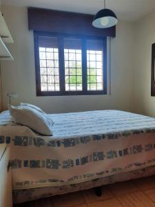 une chambre avec un lit et deux fenêtres dans l'établissement La Casa de Ana, à San Rafael