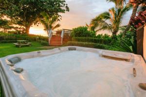 a jacuzzi tub in a yard with palm trees at The Emerald House II apts in Waialua