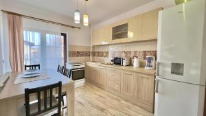 une cuisine avec des armoires en bois et un réfrigérateur blanc dans l'établissement Apartamente Simona Brasov, à Braşov