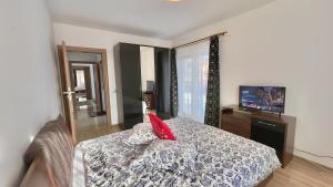 une chambre avec un lit avec un oreiller rouge dessus dans l'établissement Apartamente Simona Brasov, à Braşov