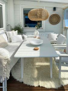 Una mesa de centro blanca en una sala de estar con un sofá en White Cabin With Jacuzzi And Fjord Views, en Bernes