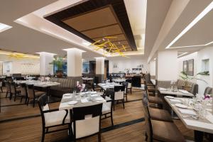 a restaurant with tables and chairs in a room at Fortune Park Galaxy, Vapi - Member ITC Hotels' Group in Vapi