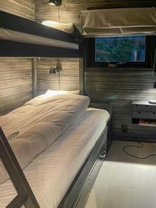 Un dormitorio con dos literas y una ventana. en White Cabin With Jacuzzi And Fjord Views, en Bernes