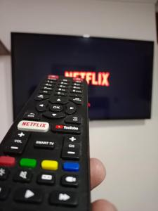 a person holding a remote control in front of a tv at Si Aparts in Santiago