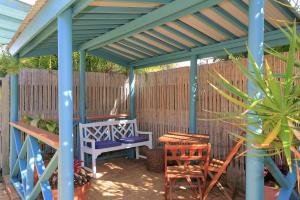 a patio area with chairs and a bench at Golden Cane Bed & Breakfast in Bargara