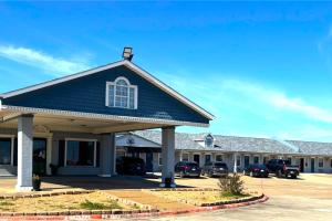 a large blue building with cars parked in a parking lot at Victorian Inn by Belvilla White sboro US Hwy 82 in Whitesboro