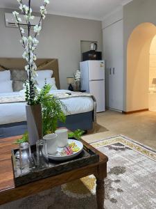 a living room with a coffee table and a bed at Kloofyard Guesthouse in Pretoria