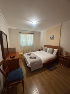 a hotel room with a bed and a chair at Ajuda Mar Holidays in Funchal