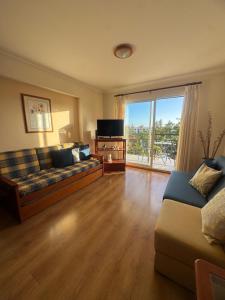 a living room with a couch and a large window at Ajuda Mar Holidays in Funchal