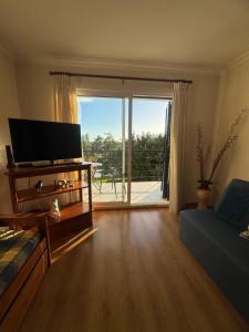 a living room with a flat screen tv and a couch at Ajuda Mar Holidays in Funchal