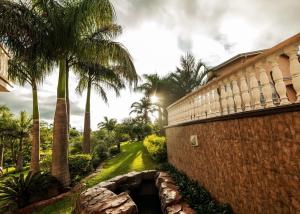a brick building with palm trees in the background at Ekupholeni Garden Villas in Manzini