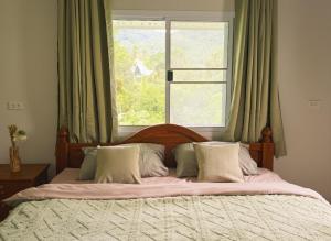ein Schlafzimmer mit einem großen Bett mit Fenster in der Unterkunft Cozy Bungalow in Ban Nua