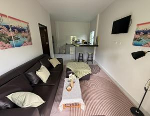 ein Wohnzimmer mit Sofa und Tisch in der Unterkunft Cozy Bungalow in Ban Nua