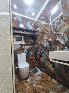 een badkamer met een toilet en een stenen muur bij بحر مباشر in Alexandrië