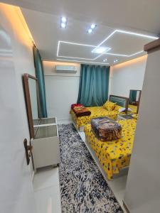 een kleine kamer met twee bedden en een spiegel bij بحر مباشر in Alexandrië